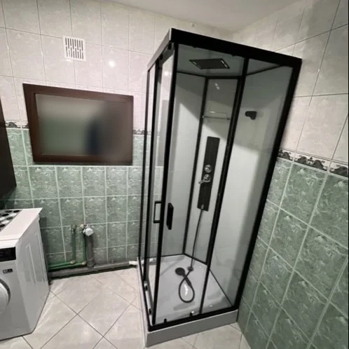 Łazienka z czarną kabiną prysznicową i pralką — DobryHydraulik Lublin